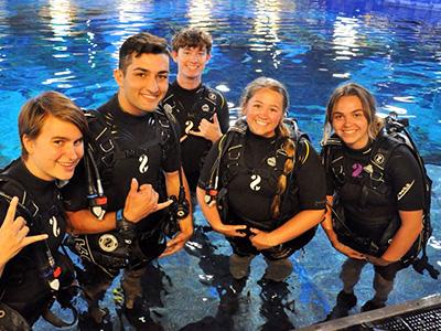 four students from the scuba club with their gear
